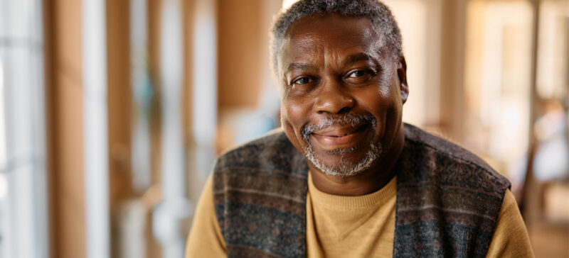 older American man smiling into the camera
