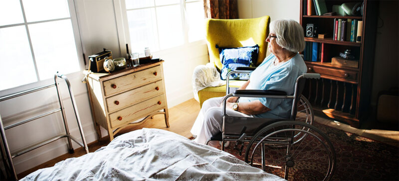 elderly woman in a wheelchair looking out window