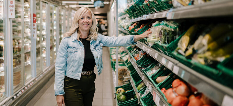 older adult shopping in the fresh vegetable section of the grocery store