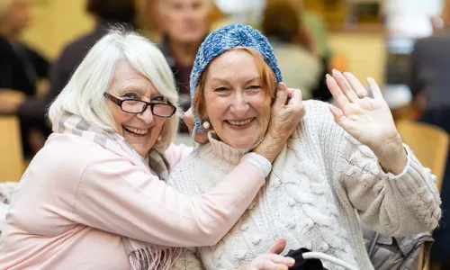 two older adult women sitting together having fun