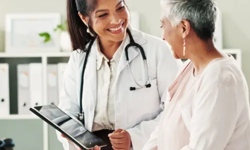 older adult woman with younger woman doctor holding a clipboard