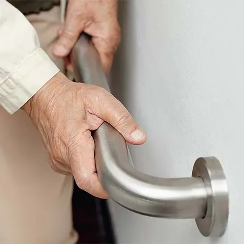 older adult person's hands utilizing a grab bar attached to a wall