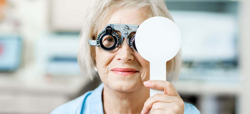 older adult woman shown getting an eye exam 